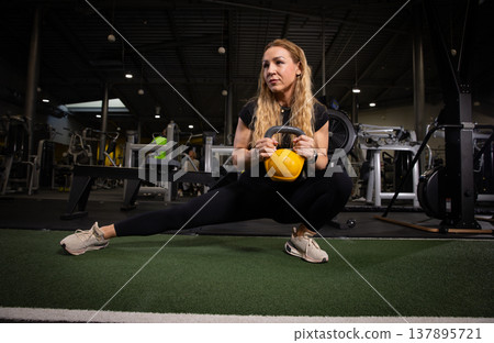 Fitness and health concept. A fit young woman works out in a modern gym. Athletic man doing exercise. Fitness and health concept. A fit young woman works out in a modern gym. Athletic man doing exercise. 137895721