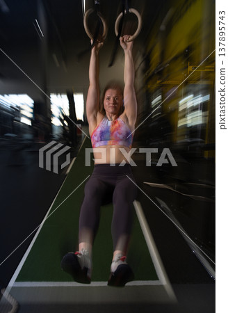 Fitness and health concept. A fit young woman works out in a modern gym. Athletic man doing exercise. Fitness and health concept. A fit young woman works out in a modern gym. Athletic man doing exercise. 137895743