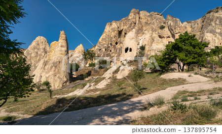 Iconic fairy chimneys and ancient rock-cut cave dwellings in Goreme, Cappadocia, Turkey on a sunny day Iconic fairy chimneys and ancient rock-cut cave dwellings in Goreme, Cappadocia, Turkey on a sunny day 137895754