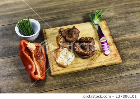 Cow bowels presented on a wooden board with ingredients, ready to grill Cow bowels presented on a wooden board with ingredients, ready to grill 137896101