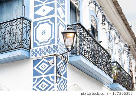 Close up of colonial blue geometric facade with wrought iron balconies Close up of colonial blue geometric facade with wrought iron balconies 137896395