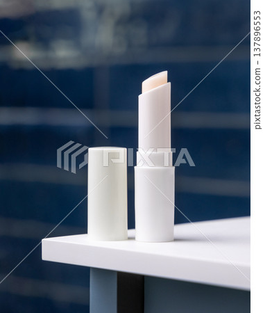 Blank lip balm stick mockup with cap in dark blue bathroom. Unbranded cosmetic packaging 137896553