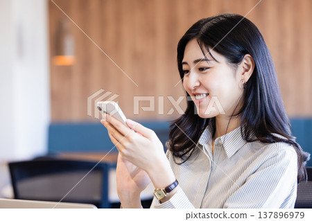 A woman operating a mobile phone 137896979