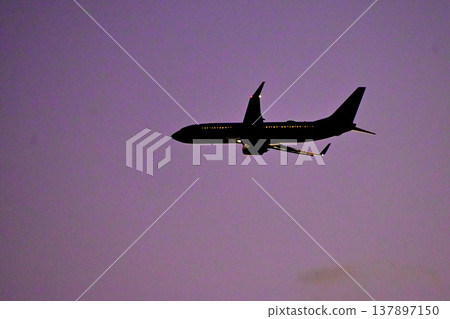 Plane taking off at dusk Plane taking off at dusk 137897150