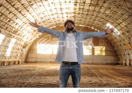 Hands to the sides, happy. Cheerful man in glasses is in hangar Hands to the sides, happy. Cheerful man in glasses is in hangar 137897170