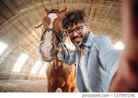 Selfie time. Man is with horse in the hangar Selfie time. Man is with horse in the hangar 137897198