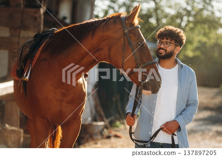Guy is with horse on the farm Guy is with horse on the farm 137897205