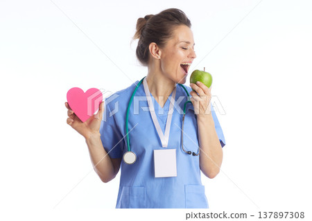 Female Doctor Biting Green Apple Holding Heart Symbol Female Doctor Biting Green Apple Holding Heart Symbol 137897308