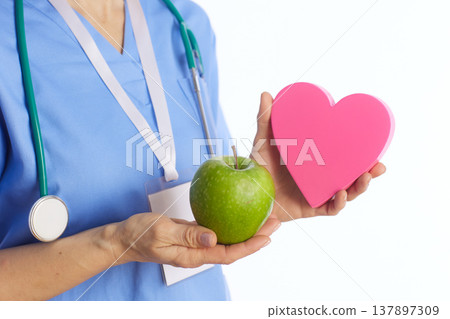 Detail Shot of Doctor Holding Healthy Heart and Apple Props Detail Shot of Doctor Holding Healthy Heart and Apple Props 137897309