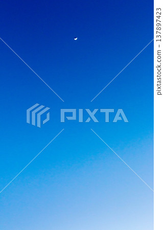 A crescent moon and a gradient of blue against the clear evening sky of February. A crescent moon and a gradient of blue against the clear evening sky of February. 137897423