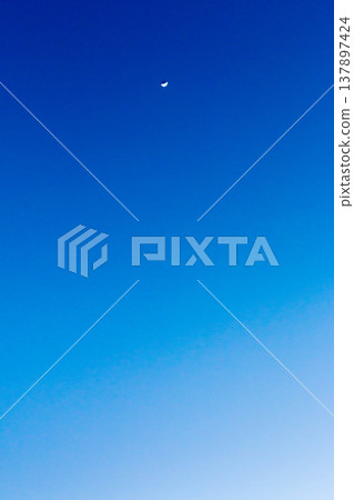 A crescent moon and a gradient of blue against the clear evening sky of February. A crescent moon and a gradient of blue against the clear evening sky of February. 137897424