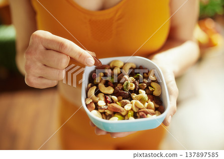 Woman Selecting a Nut from a Nutritious Snack Mix Woman Selecting a Nut from a Nutritious Snack Mix 137897585