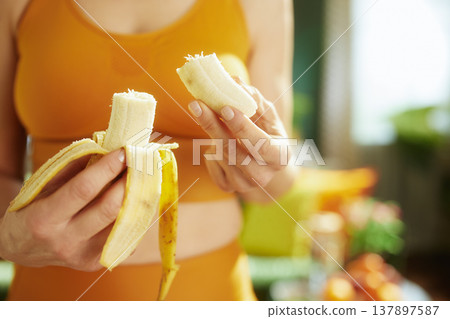 Woman in Sportswear Holding a Peeled Banana Snack Woman in Sportswear Holding a Peeled Banana Snack 137897587