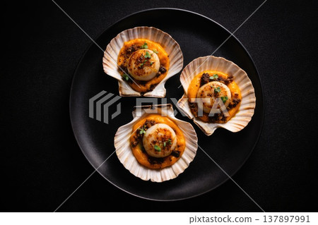 Gourmet scallops with pumpkin puree and microgreens served in shells on black plate Gourmet scallops with pumpkin puree and microgreens served in shells on black plate 137897991