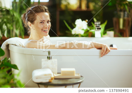 Happy Woman Enjoying a Luxurious Bubble Bath 137898491
