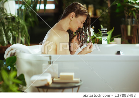 Woman Examining Hair in Relaxing Bath 137898498