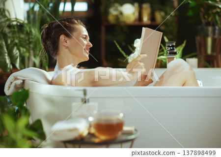 Smiling Woman Enjoying a Serene Bathtub Read Smiling Woman Enjoying a Serene Bathtub Read 137898499