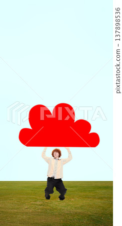 Man standing on field holding oversized cloud shape against minimal sky background. 137898536