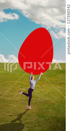 Woman jumping on green field holding oversized egg shape against cloudy sky. Woman jumping on green field holding oversized egg shape against cloudy sky. 137898542