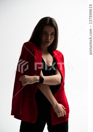 Confident female professional standing in studio, wearing a stylish red blazer and black top, looking directly at camera, portraying professionalism and fashion Confident female professional standing in studio, wearing a stylish red blazer and black top, looking directly at camera, portraying professionalism and fashion 137898618