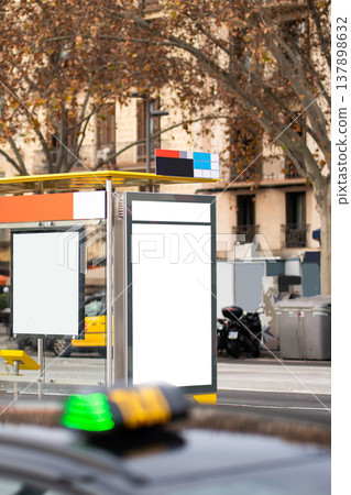 White mock-up outdoor billboards at a modern city bus stop providing promotional space for advertising campaigns, with a taxi passing by creating an urban backdrop White mock-up outdoor billboards at a modern city bus stop providing promotional space for advertising campaigns, with a taxi passing by creating an urban backdrop 137898632