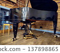 A tenor saxophone rests on the stage floor beneath a grand piano. 137898865