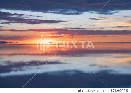 Serene sunset sky reflection on water of Uyuni salt flat Bolivia Serene sunset sky reflection on water of Uyuni salt flat Bolivia 137899058