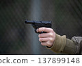 A child's hand holding a toy gun 137899148