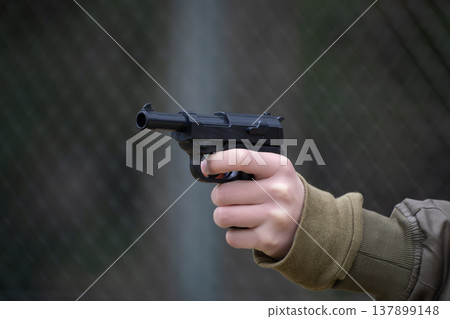 A child's hand holding a toy gun 137899148