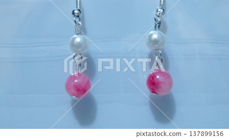 Close-up of handmade earrings for women or girls isolated in white background. Beautiful pearl and pink stones earrings. Fashion and accessory concepts. Close-up of handmade earrings for women or girls isolated in white background. Beautiful pearl and pink stones earrings. Fashion and accessory concepts. 137899156