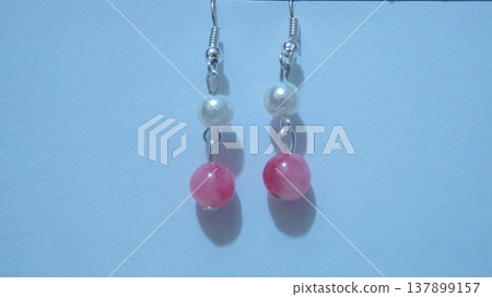 Close-up of handmade earrings for women or girls isolated in white background. Beautiful pearl and pink stones earrings. Fashion and accessory concepts. Close-up of handmade earrings for women or girls isolated in white background. Beautiful pearl and pink stones earrings. Fashion and accessory concepts. 137899157