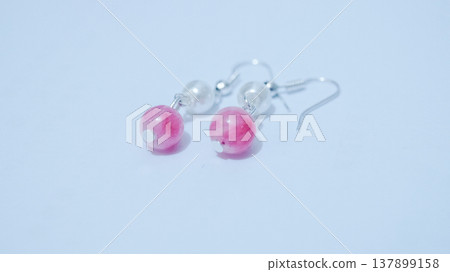 Close-up of handmade earrings for women or girls isolated in white background. Beautiful pearl and pink stones earrings. Fashion and accessory concepts. Close-up of handmade earrings for women or girls isolated in white background. Beautiful pearl and pink stones earrings. Fashion and accessory concepts. 137899158