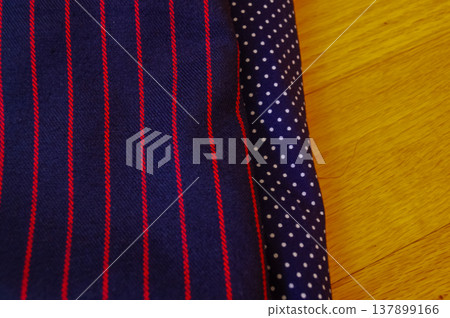 Close-up of fabric with dots and strips pattern for making clothes. Clothing and fabric concept. Close-up of fabric with dots and strips pattern for making clothes. Clothing and fabric concept. 137899166