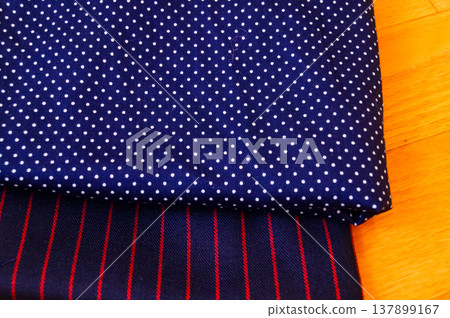 Close-up of fabric with dots and strips pattern for making clothes. Clothing and fabric concept. Close-up of fabric with dots and strips pattern for making clothes. Clothing and fabric concept. 137899167