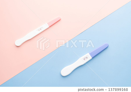 Positive urine pregnancy test on pink and blue background. Pregnancy test kit measure hCG levels in urine. Baby gender concept. 137899168