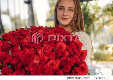 Happy young woman is with big bouquet of roses Happy young woman is with big bouquet of roses 137899220