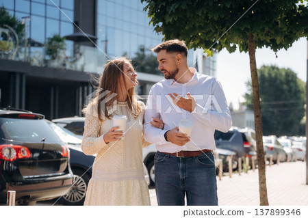 Cups of drinks in hands. Happy couple together outdoors Cups of drinks in hands. Happy couple together outdoors 137899346
