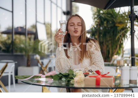Cheerful woman is sitting in outdoor restaurant 137899441