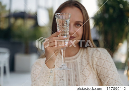 Cheerful woman is sitting in outdoor restaurant Cheerful woman is sitting in outdoor restaurant 137899442