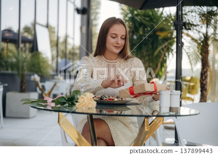 Cheerful woman is sitting in outdoor restaurant 137899443
