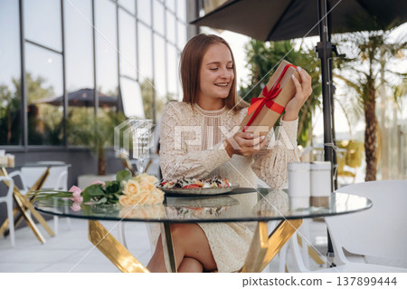 Cheerful woman is sitting in outdoor restaurant Cheerful woman is sitting in outdoor restaurant 137899444