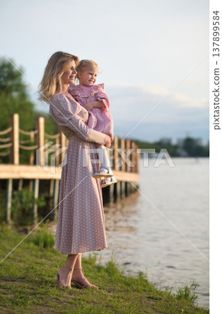 Joyful child pointing excitedly, held by a smiling woman. Captures the thrill of discovery and maternal warmth. Joyful child pointing excitedly, held by a smiling woman. Captures the thrill of discovery and maternal warmth. 137899584