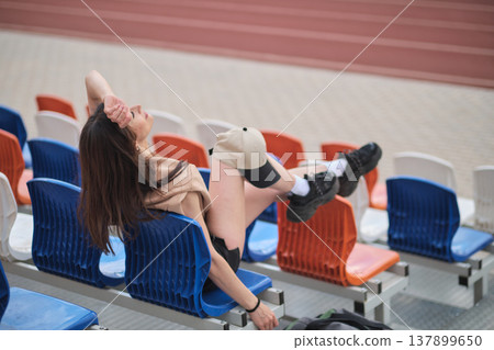 woman in blue sportswear performs a leg lift exercise with a Pilates ring on a mat. This photo captures the essence of focused workout sessions and the importance of physical health. woman in blue sportswear performs a leg lift exercise with a Pilates ring on a mat. This photo captures the essence of focused workout sessions and the importance of physical health. 137899650