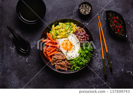 Traditional Korean dish Bibimbap: rice with vegetables beef and egg. Traditional Korean dish Bibimbap: rice with vegetables beef and egg. 137899743