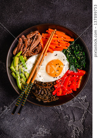 Traditional Korean dish Bibimbap: rice with vegetables beef and egg. 137899753
