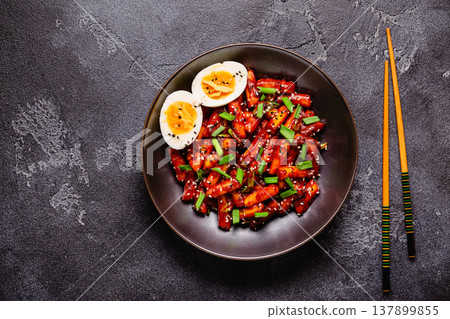 Tteokbokki, Teopokki fried rice cake in black bowl. Tteokbokki, Teopokki fried rice cake in black bowl. 137899855