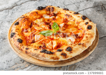 Hot Italian pizza with smoked chicken, brie cheese and sun-dried tomatoes close-up on a wooden board. Horizontal 137899881