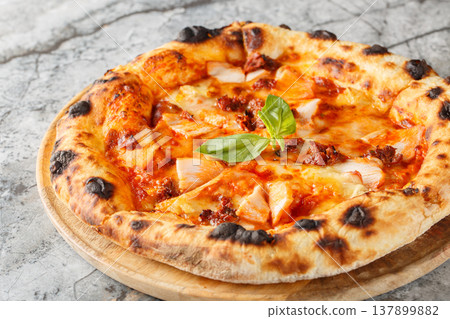 Authentic Italian pizza with smoked chicken, brie cheese and sun-dried tomatoes close-up, on a wooden board. Horizontal 137899882