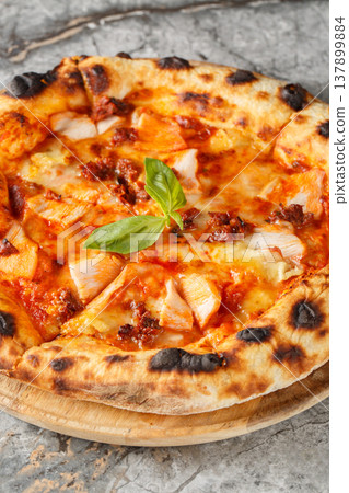 Charred pizza with smoked chicken, brie cheese and sun-dried tomatoes close-up on a wooden board. Vertical Charred pizza with smoked chicken, brie cheese and sun-dried tomatoes close-up on a wooden board. Vertical 137899884