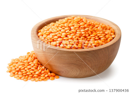 Red lentils in a wooden plate and a pile on a white background. Isolated 137900436